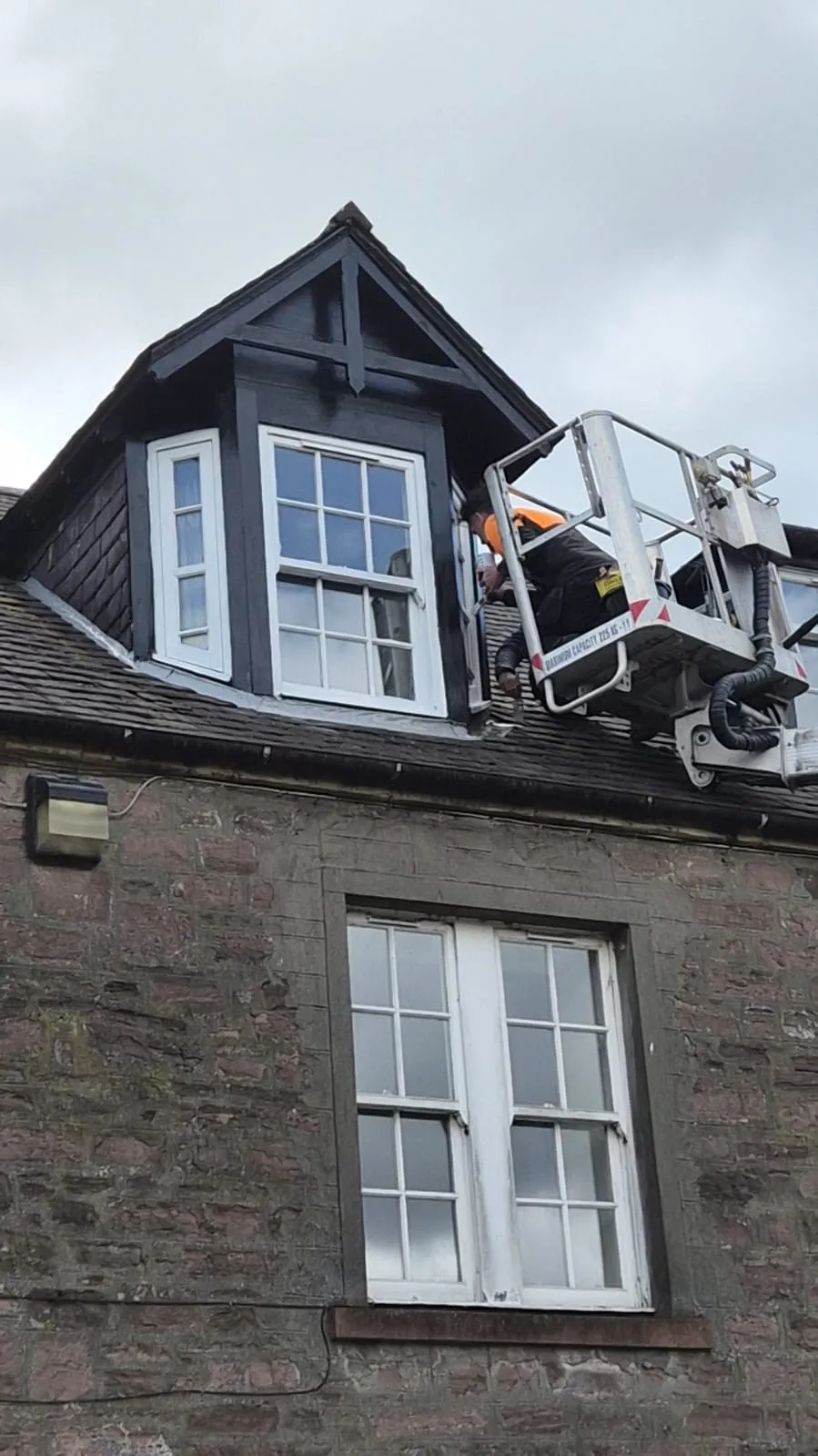 Roofer carrying out dormer leadwork and repair from a cherry picker in Alloa