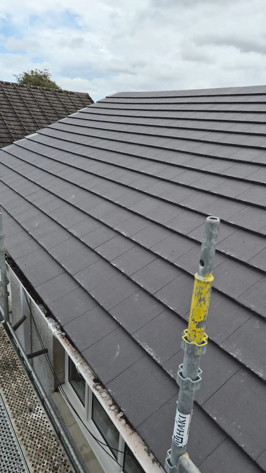 Finished tiling on a re-roofed bungalow showing clean, even courses up to the ridge