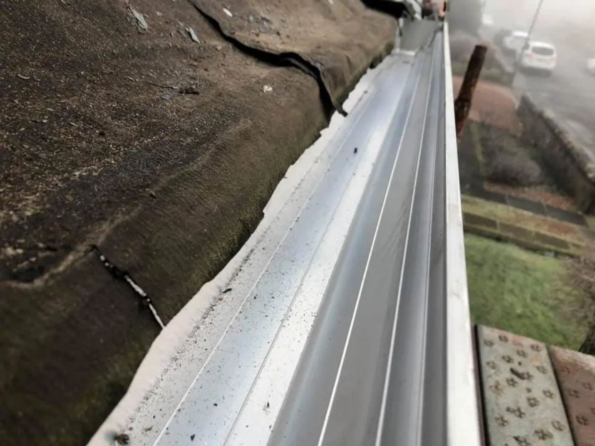 New guttering being installed along a roofline