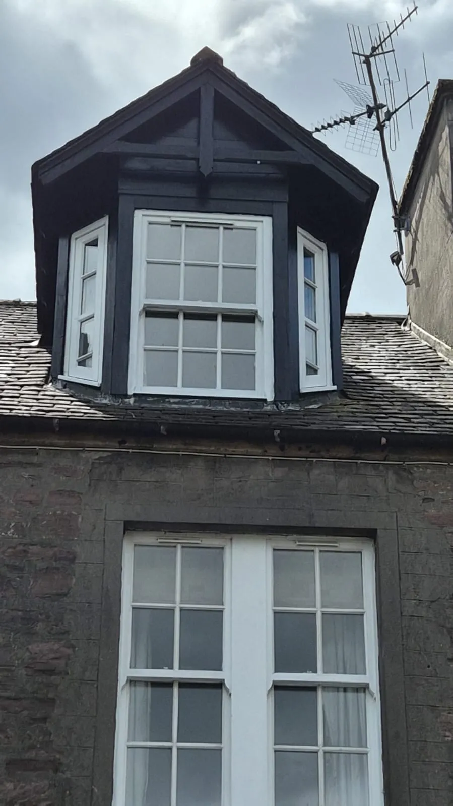 Restored dormer window with fresh paintwork and lead flashing on a traditional Scottish stone tenement