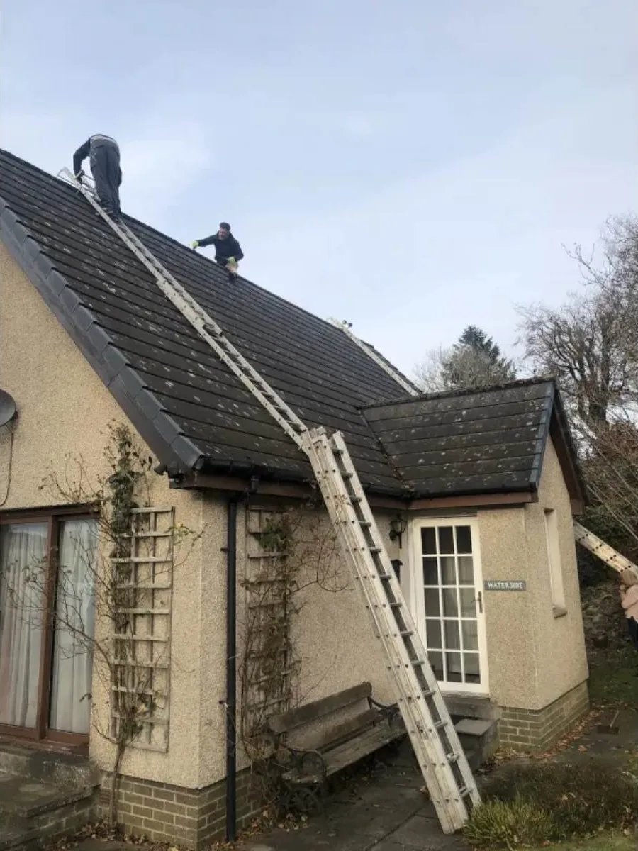 Roofers working on a slate roof in the Forth Valley