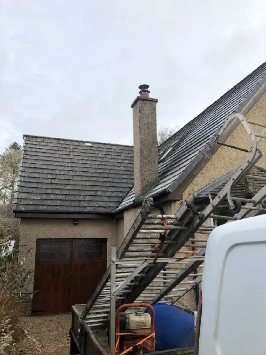Slate roof with chimney and scaffolding access for repair work